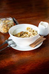 a bowl of cereal with bananas and nuts on a table at Tribe Bungalows, Bwejuu, Zanzibar in Bwejuu