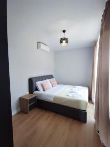 a bedroom with a bed with a black headboard at Bright Spacious Family Apartment in White Sails in Batumi