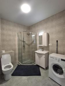 a bathroom with a shower and a toilet and a sink at Bright Spacious Family Apartment in White Sails in Batumi