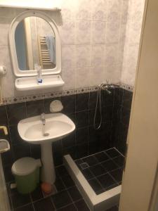 a small bathroom with a sink and a mirror at Stan na dan in Kragujevac