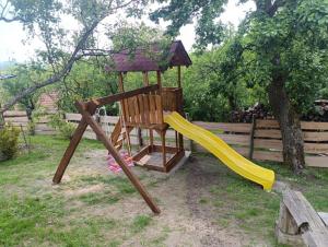 a wooden playground with a slide at Chata Blaženka štýlový únik do prirody in Chvojnica