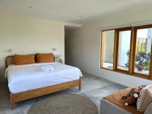 a bedroom with a large bed and a window at Villa Aura Lombok in Selong Belanak