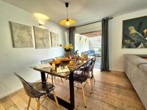 une salle à manger avec une table, des chaises et un canapé dans l'établissement La Maison des Iris - clim - patio - parking, à Nîmes 20 autres photos