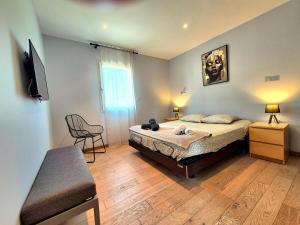 une chambre avec un lit et une télévision dans l'établissement La Maison des Iris - clim - patio - parking, à Nîmes