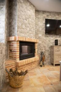a living room with a stone fireplace with a tv at Casa Rural El Pozo in Guadamur