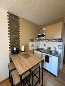 a kitchen with a wooden table and a kitchen with a sink at Les Logis de Paray - App 224 in Paray-le-Monial