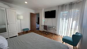 a bedroom with a bed and a desk and a television at Apartamento cristo 20 en arenas de velez malaga in Arenas