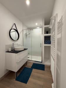 エルマンヴィル・シュル・メールにあるMaison de charme sur la côteの洗面台とシャワー付きの白いバスルーム