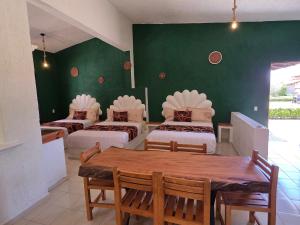 a room with four beds and a table and a green wall at Hotel Rancho Las Margaritas in Valle de Bravo