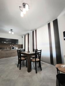 a dining room with a table and chairs and a kitchen at Apartment Active Sport in Pazardzhik