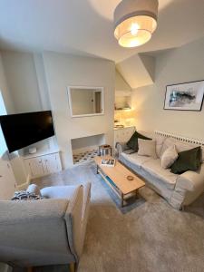 a living room with two couches and a tv at Cosy cottage in Kendal in Kendal