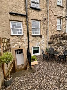 a patio with a table and chairs in front of a building at Cosy cottage in Kendal in Kendal