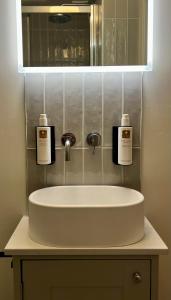 a bathroom sink with two bottles of soap on it at Cosy cottage in Kendal in Kendal