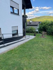 a house with a grassy yard next to a building at Familienglück im Odenwald in Grasellenbach