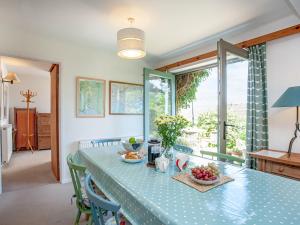ein Esszimmer mit einem blauen Tisch mit Obst darauf in der Unterkunft The Cottage in Salcombe