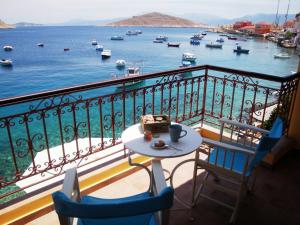 a balcony with a table and chairs and a view of the water at Halkis Muses in Halki