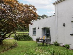 a table in the backyard of a white house at Beach Hideaway in Bideford