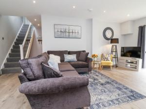a living room with a couch and a tv at Beach Hideaway in Bideford