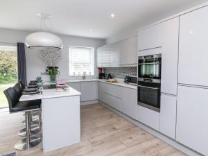 a kitchen with white cabinets and a white counter top at Beach Hideaway in Bideford +17 photos