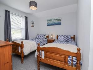 a bedroom with two beds and a window at Beach Hideaway in Bideford