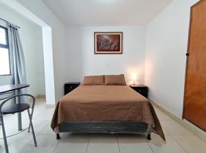 a bedroom with a bed and a table and a window at Hostal Casa Coliving Medellin in Medellín