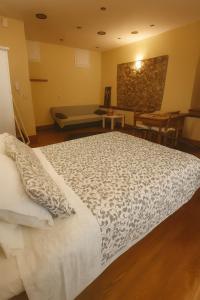 a bedroom with a large bed and a couch at Spianada Dimora Corfu in Corfu Town +6 photos