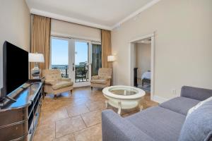a living room with a couch and a tv at Sea Gate #307 in Demere Park