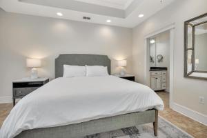 a bedroom with a large white bed and a window at Sea Gate #307 in Demere Park +28 photos