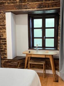 Zimmer mit einem Holztisch und einem Fenster in der Unterkunft Cantábrico Fonsagrada in A Fonsagrada + 29 Fotos