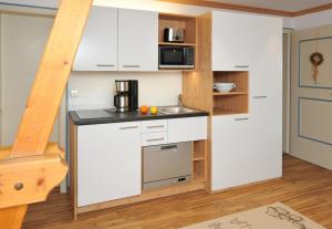 a kitchen with white cabinets and a counter top at Gästehaus Klara in Reit im Winkl