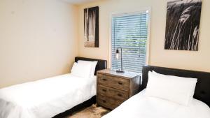 a bedroom with two beds and a window at Watermen's Cabana 1C - 3-Bed, 2-Bath Apartment - Walk To BEACH Access & PET Friendly! in Waves +24 photos