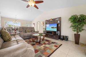 珊瑚角Villa Yvonne的客厅里有一张沙发和一台电视