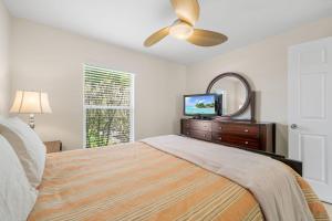 珊瑚角Villa Yvonne的一间带床、镜子和电视的卧室 更多14张照片