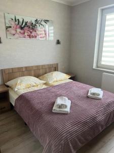 a bedroom with a bed with two towels on it at Apartamenty Bursztynowe in Dębki