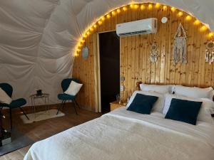 a bedroom with a bed and chairs in a tent at Sunrise Glamping Retreat in Galeşu +47 photos