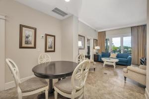 Una sala de estar con una mesa y sillas y un sofá. en Sea Gate #305, en Demere Park