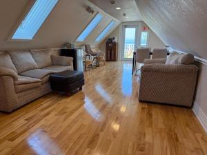 a living room with two couches and a table at Fundy Footprints in Saint Martins