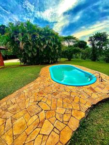 a swimming pool on top of a stone patio at Casa de Campo - Espaço Garden in Novo Hamburgo