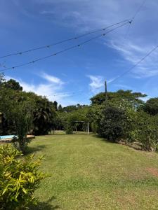 a field of grass with trees in the background at Casa de Campo - Espaço Garden in Novo Hamburgo