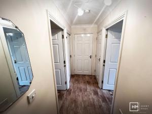 a hallway with two doors and a mirror at Canalside Chic Your London Escape Starts Here WIFI and Airport Transfers in Hemel Hempstead