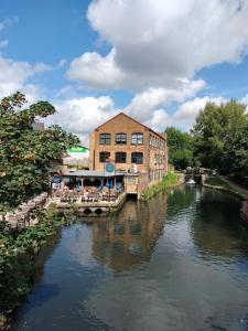 a bridge over a river in front of a building at Canalside Chic Your London Escape Starts Here WIFI and Airport Transfers in Hemel Hempstead