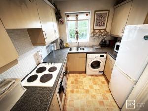 a kitchen with a stove and a sink and a refrigerator at Canalside Chic Your London Escape Starts Here WIFI and Airport Transfers in Hemel Hempstead +16 photos