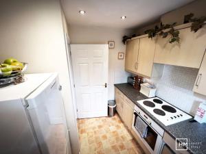 a kitchen with white cabinets and a stove top oven at Canalside Chic Your London Escape Starts Here WIFI and Airport Transfers in Hemel Hempstead