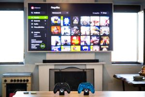 a tv above a fireplace with two video game controllers at Cinema & Gaming House with View in Skotina