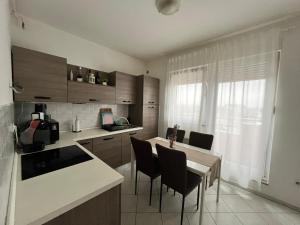 a kitchen with a table and chairs and a kitchen with a counter at Apartment Aurora in Buzin