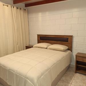 a bedroom with a white bed with two pillows at Alto Jere in Toconao