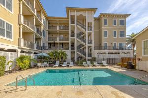 an apartment with a swimming pool in front of a building at Sea Gate #105 in Demere Park +21 photos