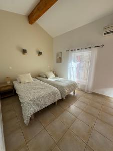 ein Schlafzimmer mit zwei Betten und einem Fenster in der Unterkunft L'Estaple in Berlou + 19 Fotos