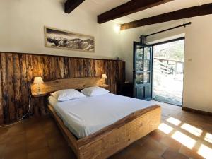 a bedroom with a bed with a wooden wall at Maison des Cévennes in Arphy