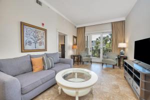 a living room with a couch and a tv at Sea Gate #103 in Saint Simons Island